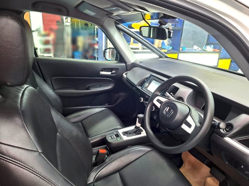 Honda Fit cabin with black leather seats and steering wheel after the refresh.