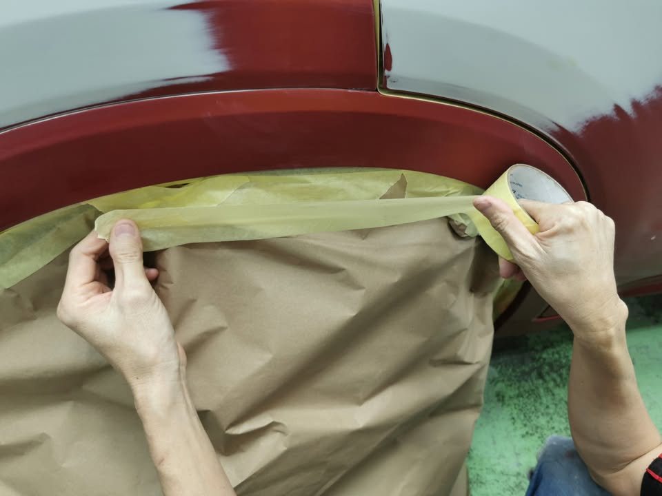 Taping paper over the wheel arch of the HR-V.