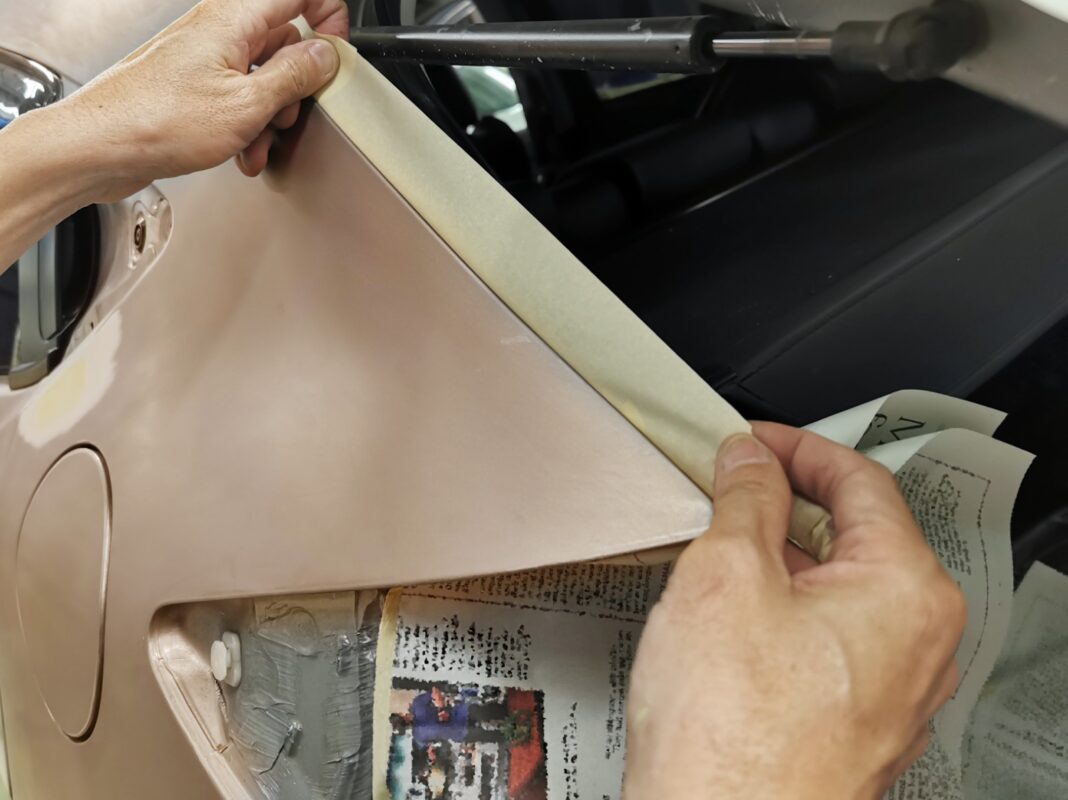 Masking tape and paper applied to the Honda HR-V ahead of the spray booth.