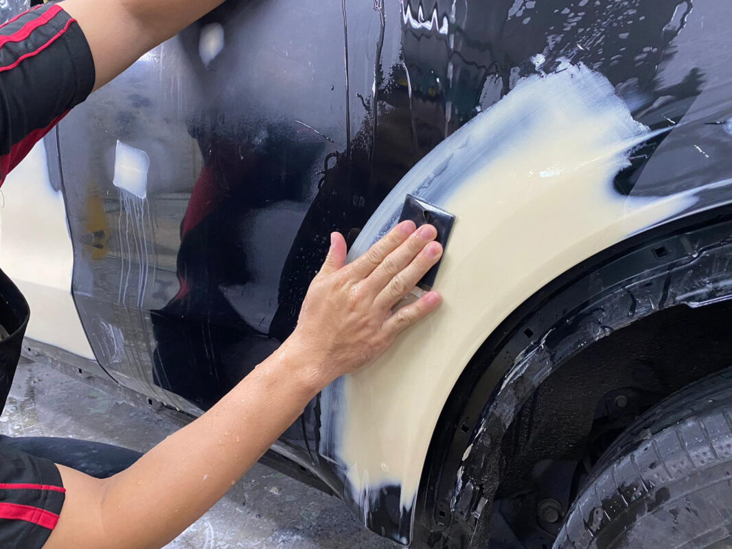 Wet-sanding the Honda HR-V's surface to level it before painting.
