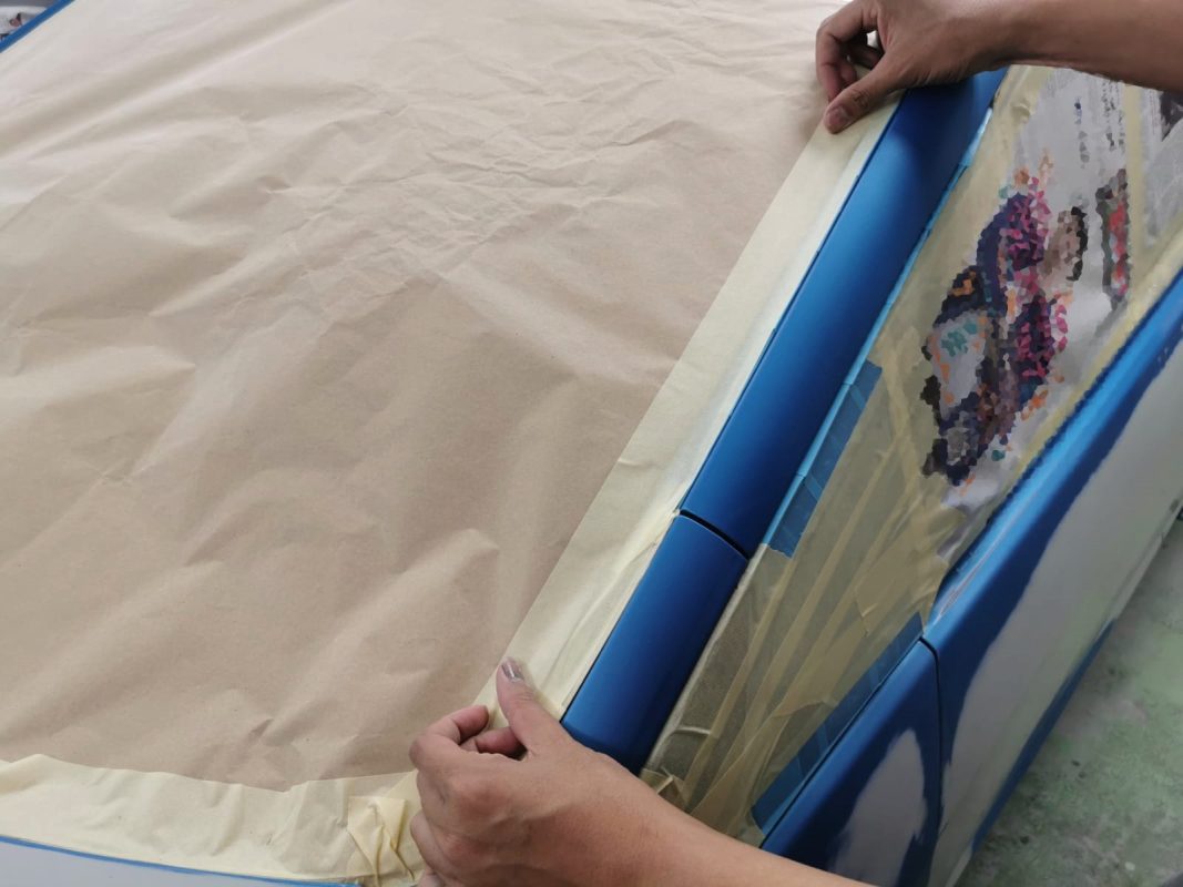 Masking the Honda Jazz before the spray booth, all non-painted surfaces covered.