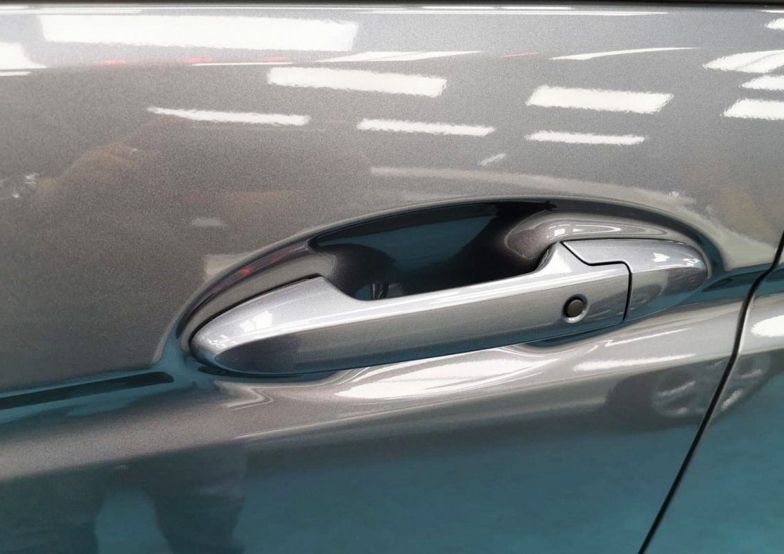 The coated bonnet of the Honda Jazz under workshop lighting.