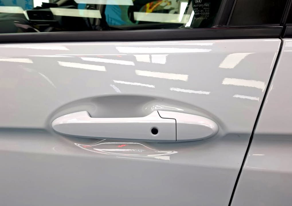 Close-up of the white door panel around the door handle.