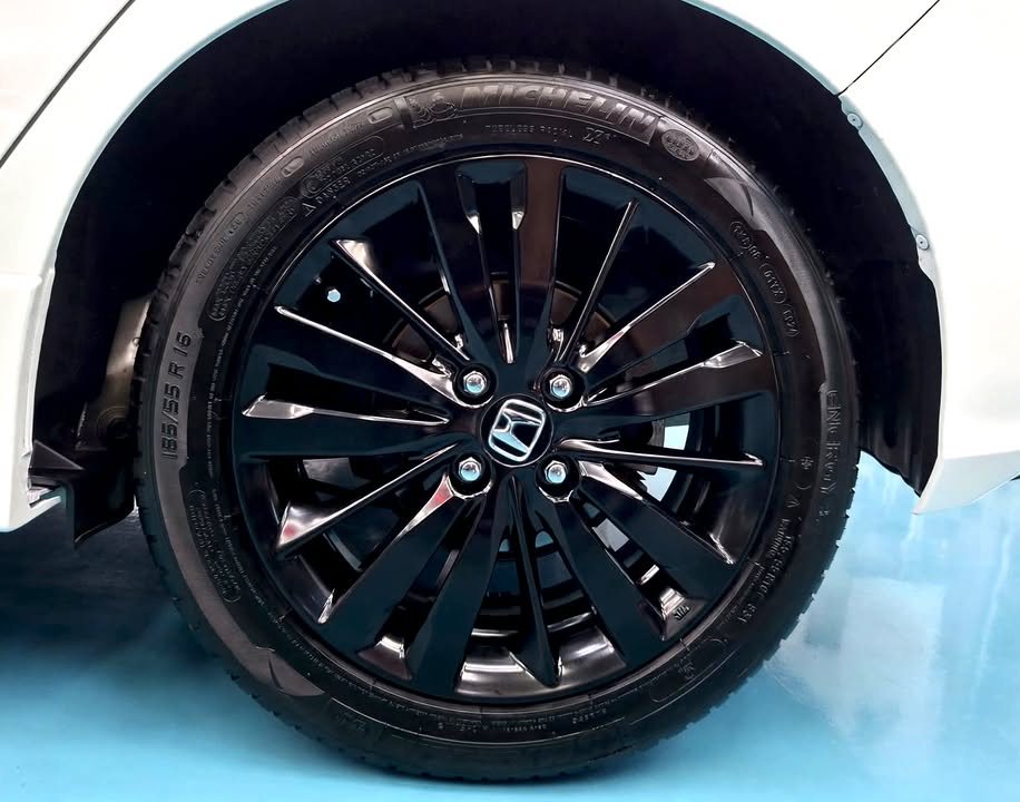 Black multi-spoke alloy wheel under the white wheel arch.