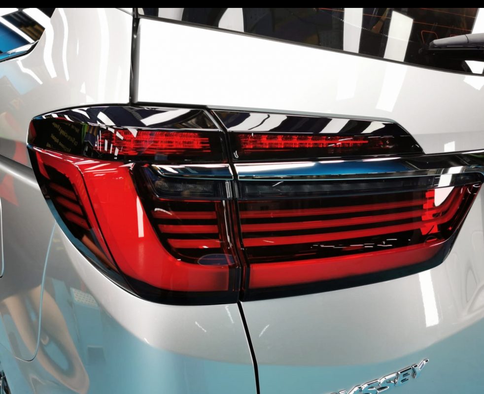 The coated bonnet of the Honda Odyssey under workshop lighting.