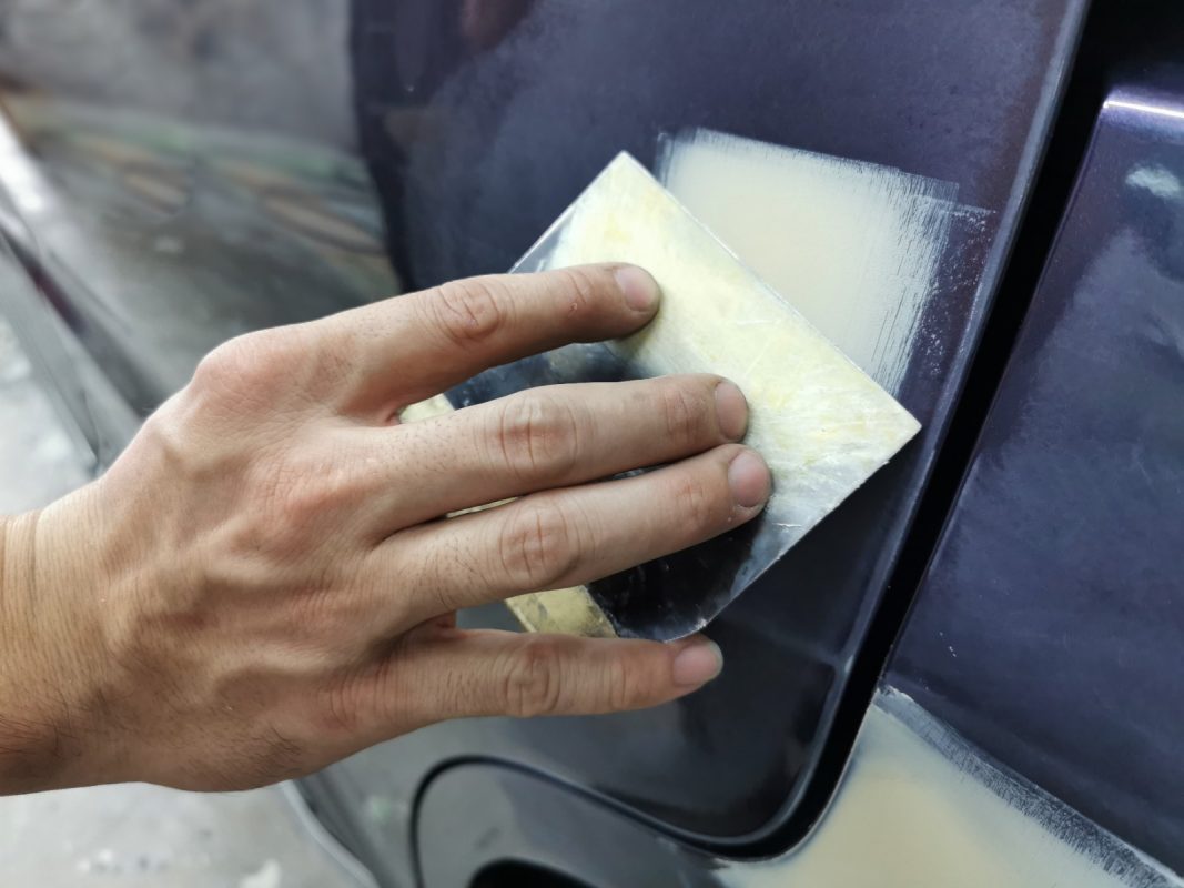 Checking the body for paintwork imperfections and patching them.