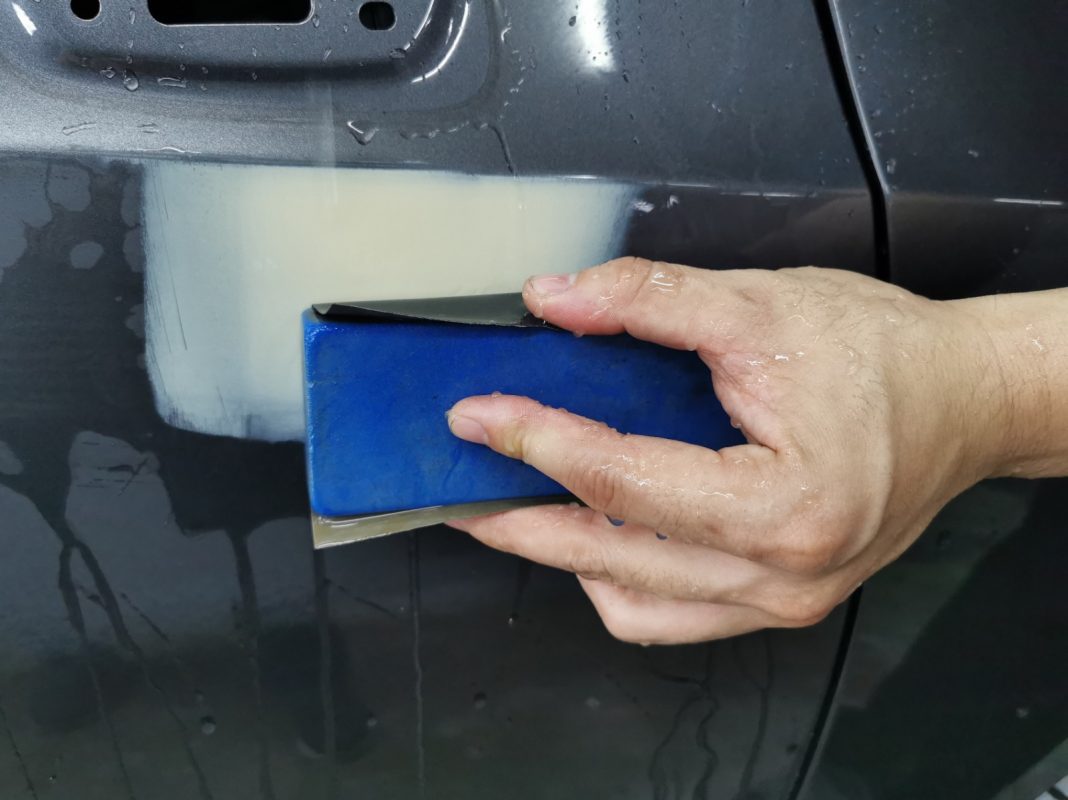 Wet-sanding the Odyssey's panels to smooth the existing paintwork.