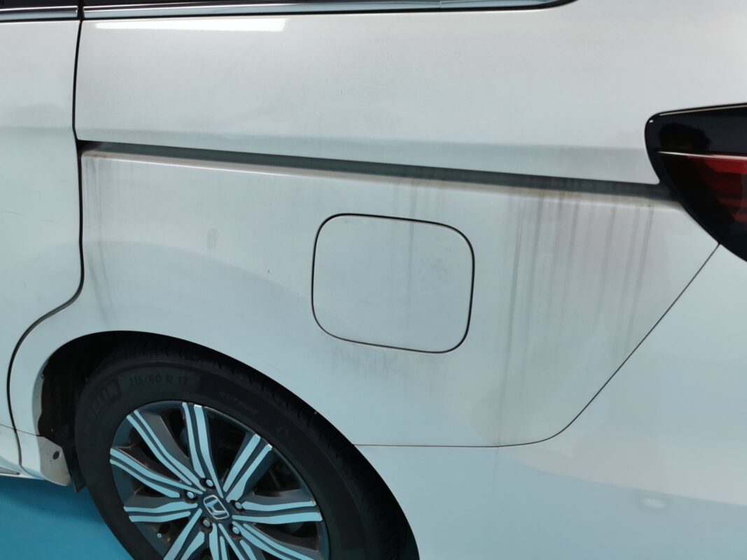The Honda Odyssey's rear quarter panel marked with water stains before the respray.