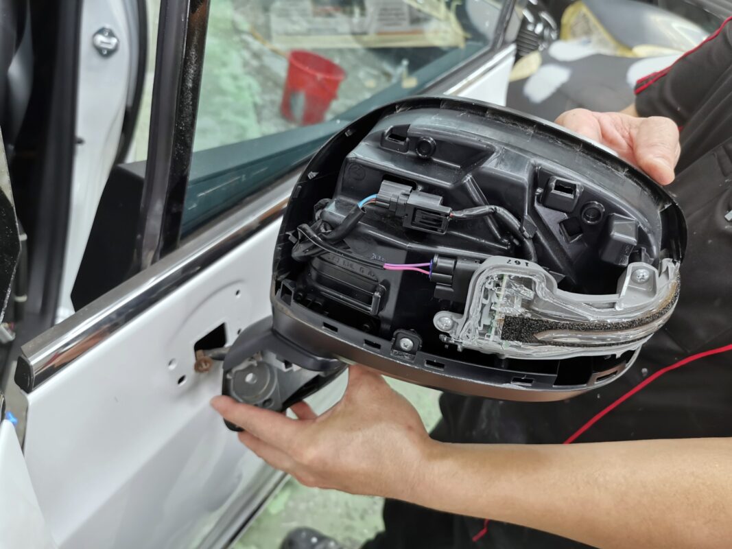 The Honda Odyssey's side mirror taken off and opened up during strip-down.