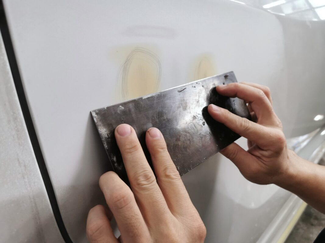 Body filler applied and shaped on a panel of the Honda Odyssey.
