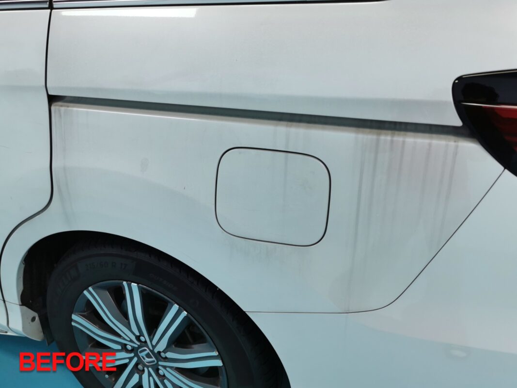 Before: the Honda Odyssey's rear quarter panel at the start, dulled and stained.