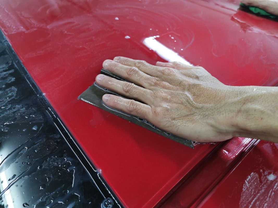 Wet-sanding the Shuttle's panels to smooth the existing paintwork.