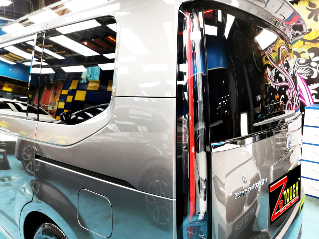 The coated bonnet of the Honda Stepwagon Spada under workshop lighting.
