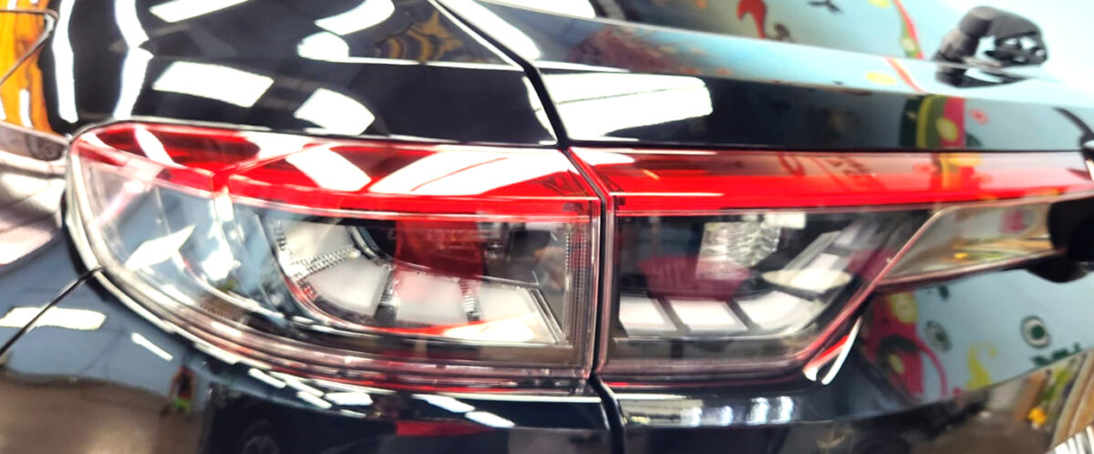 The coated bonnet of the Honda Vezel under workshop lighting.