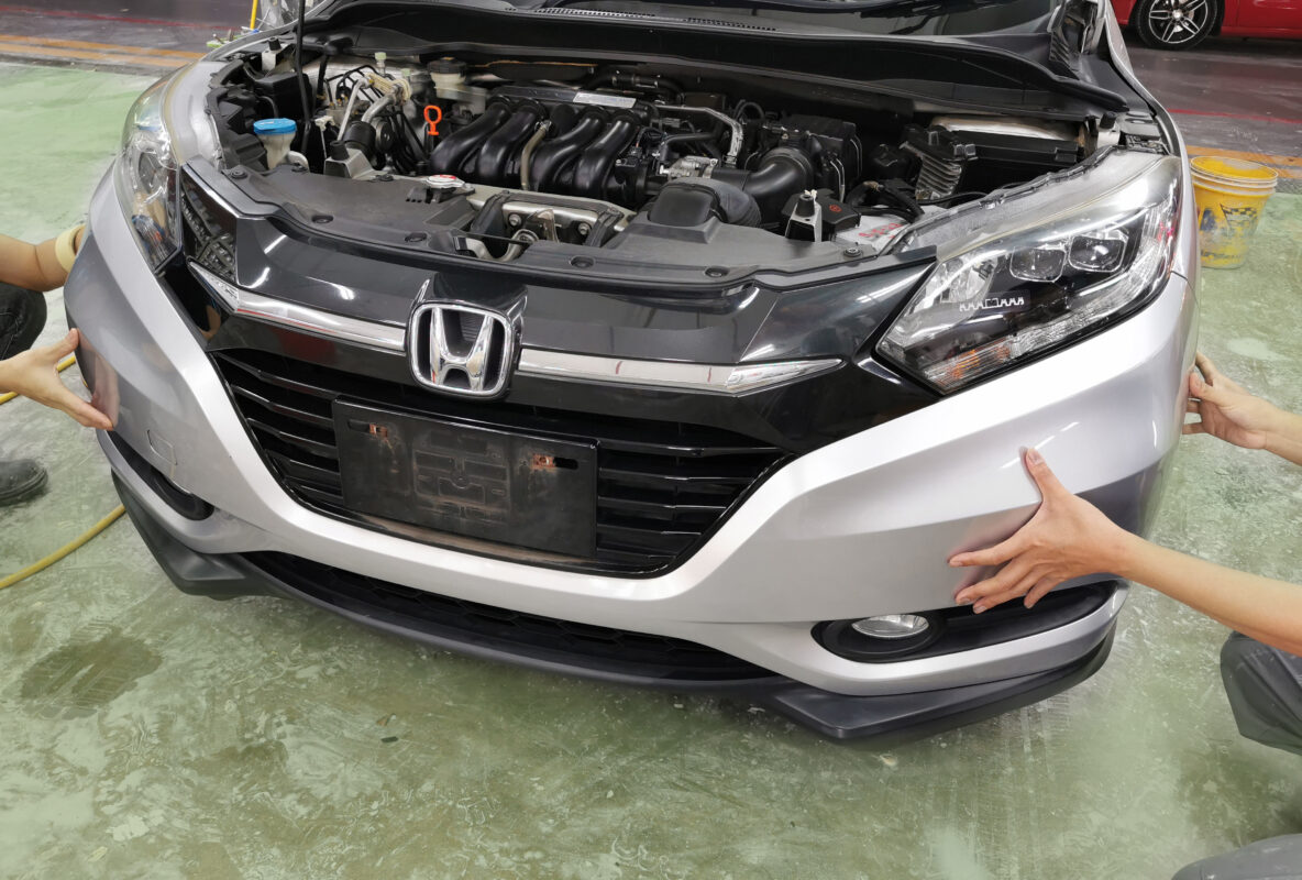 A Revol Carz technician removing parts from the Honda Vezel during strip-down.