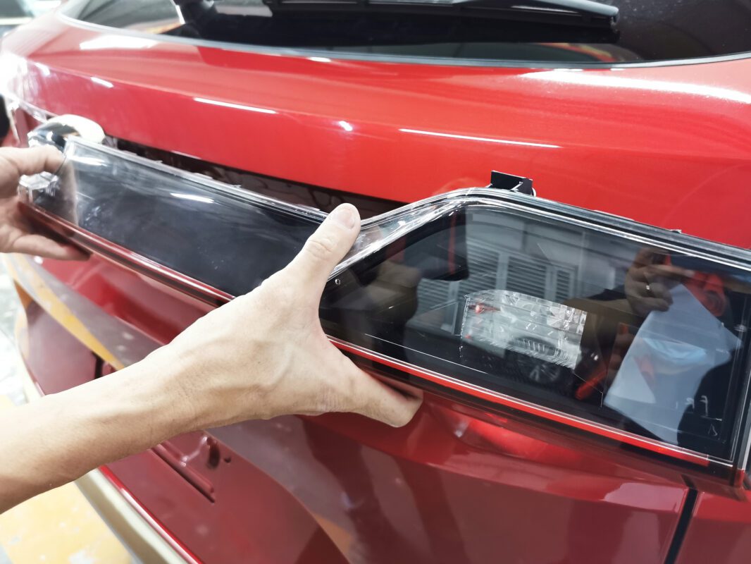 A technician beginning strip-down on the Honda Vezel, panels coming off.
