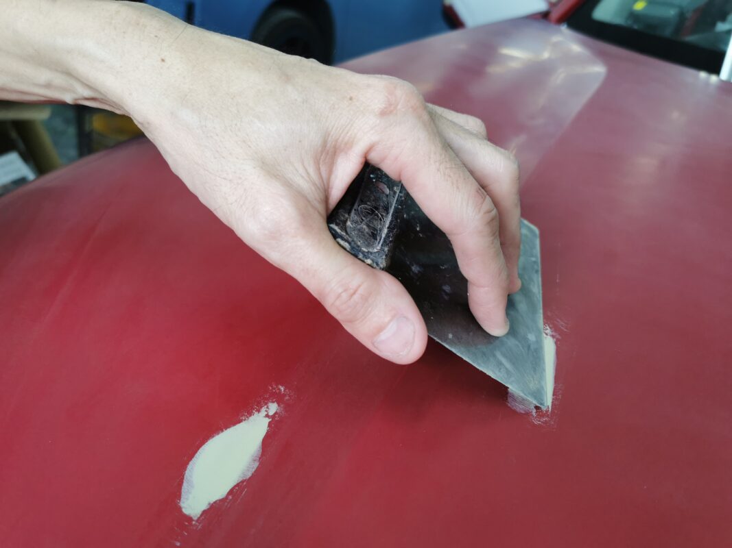 Hand-sanding a panel on the Honda Vezel to smooth out imperfections.