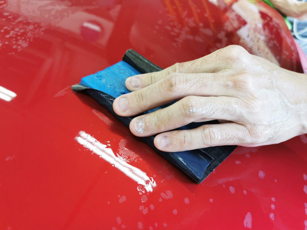 Wet-sanding the Honda Vezel's panels to bring the surface level.