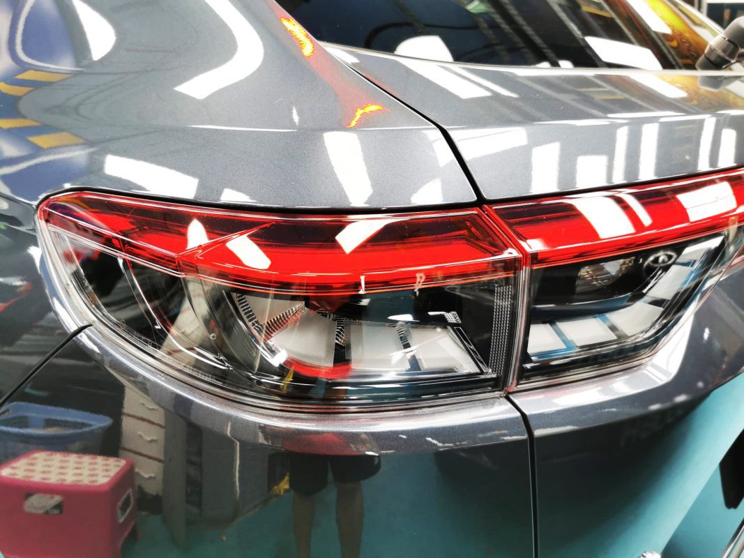 The coated bonnet of the Honda Vezel under workshop lighting.