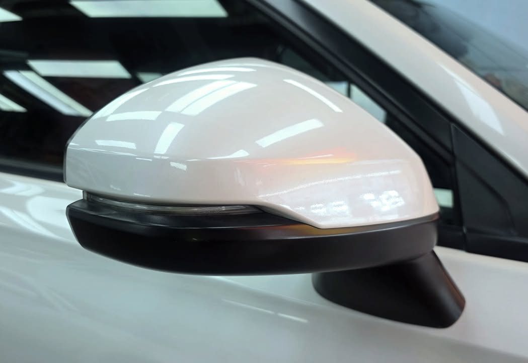 White side mirror cap with a black base, showing a glossy reflection.