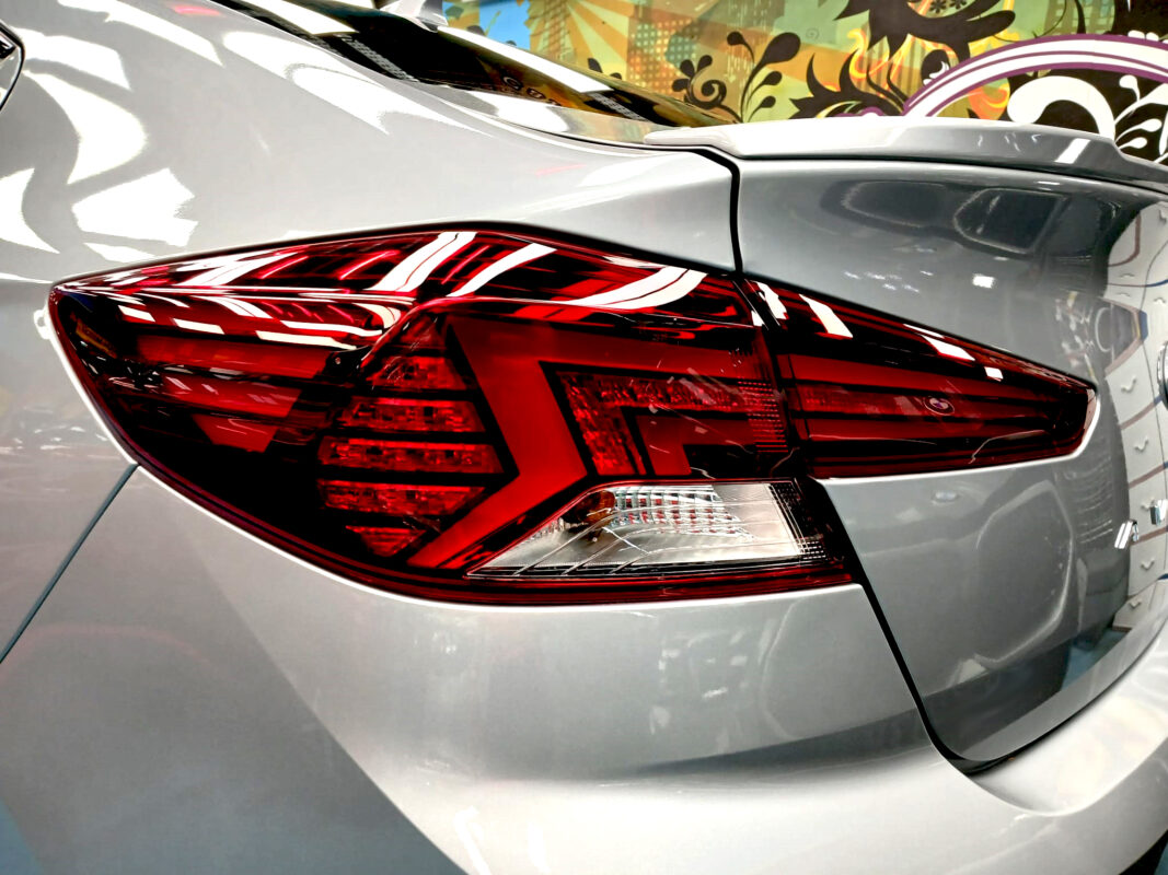 The coated bonnet of the Hyundai Avante under workshop lighting.
