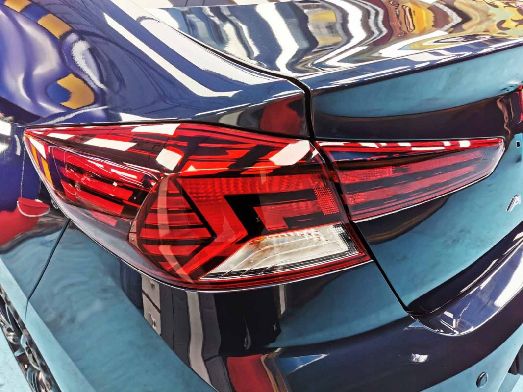 The coated bonnet of the Hyundai Avante under workshop lighting.