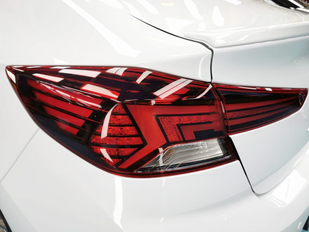 The coated bonnet of the Hyundai AD Avante under workshop lighting.