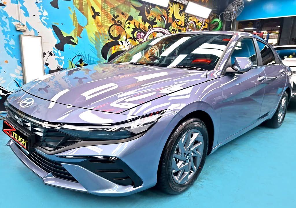 Blue grey Hyundai Avante sedan, front three-quarter view, in the Revol Carz workshop after coating.