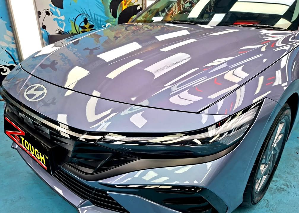 Bonnet and front of the Hyundai Avante with workshop lights reflected in the paint.