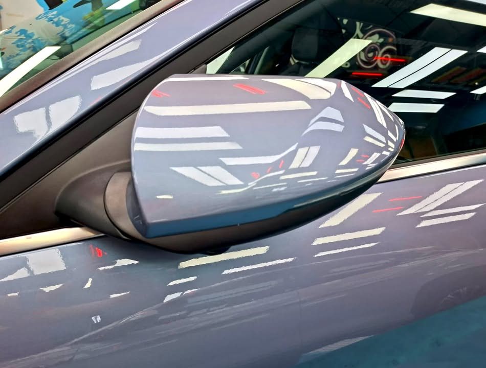 Blue grey wing mirror on the Avante reflecting the workshop lights.