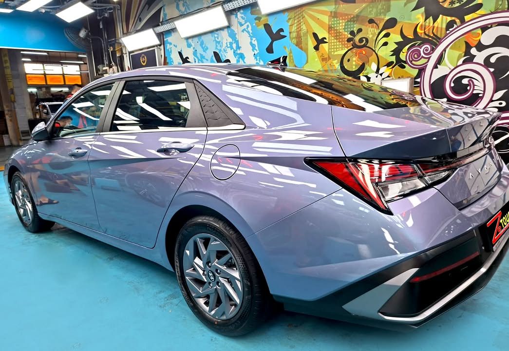 Blue grey Hyundai Avante, rear three-quarter view, in the workshop.
