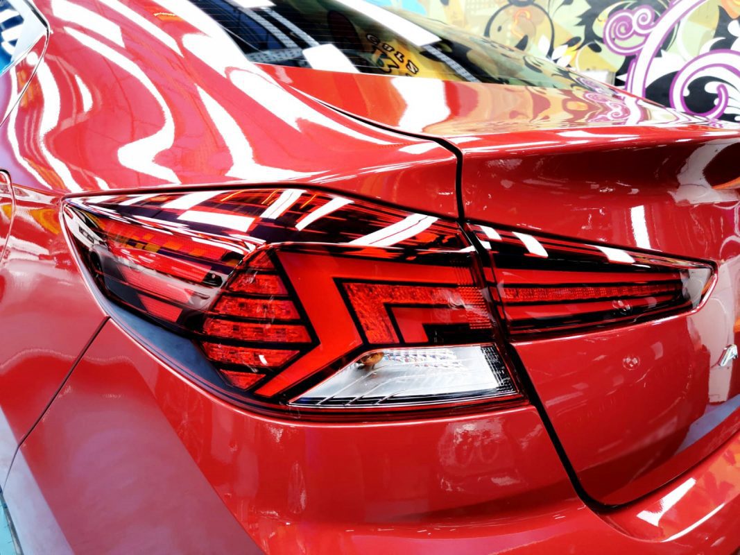 The coated bonnet of the Hyundai Avante under workshop lighting.