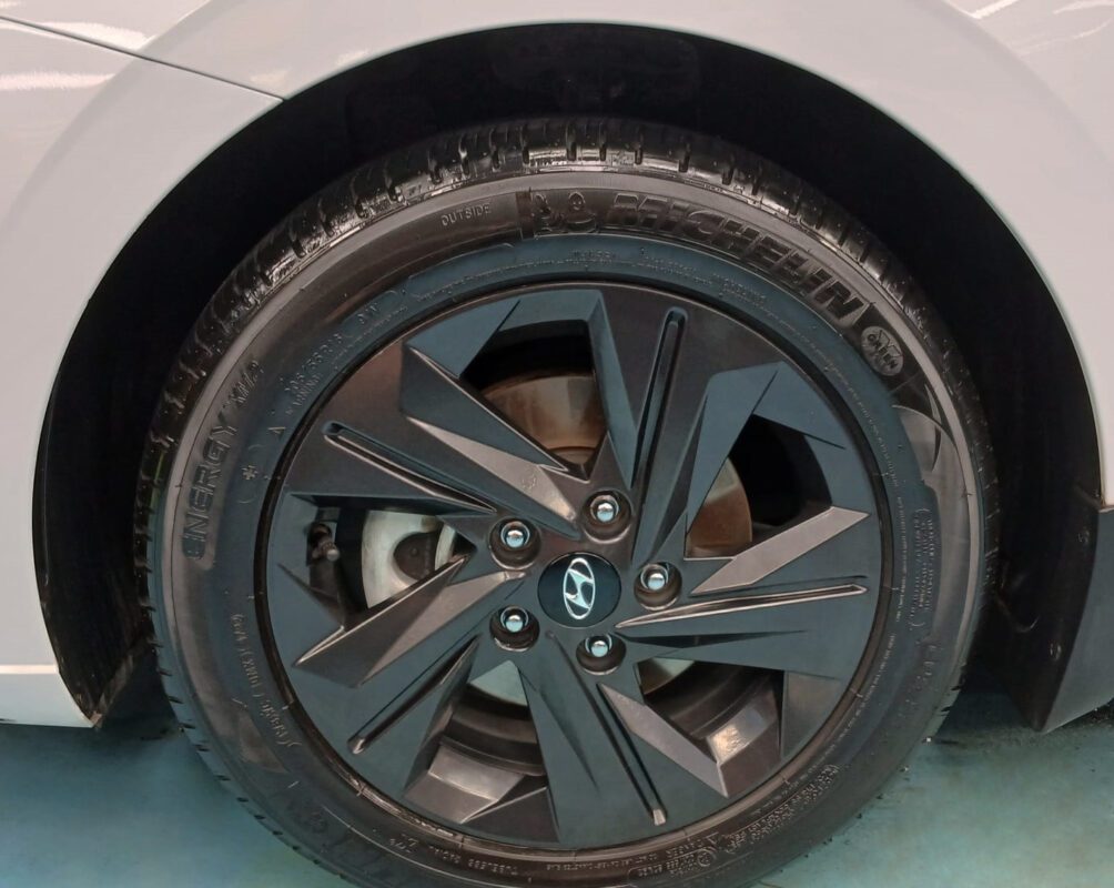 The coated bodywork of the Hyundai CN7 Avante under workshop lighting.