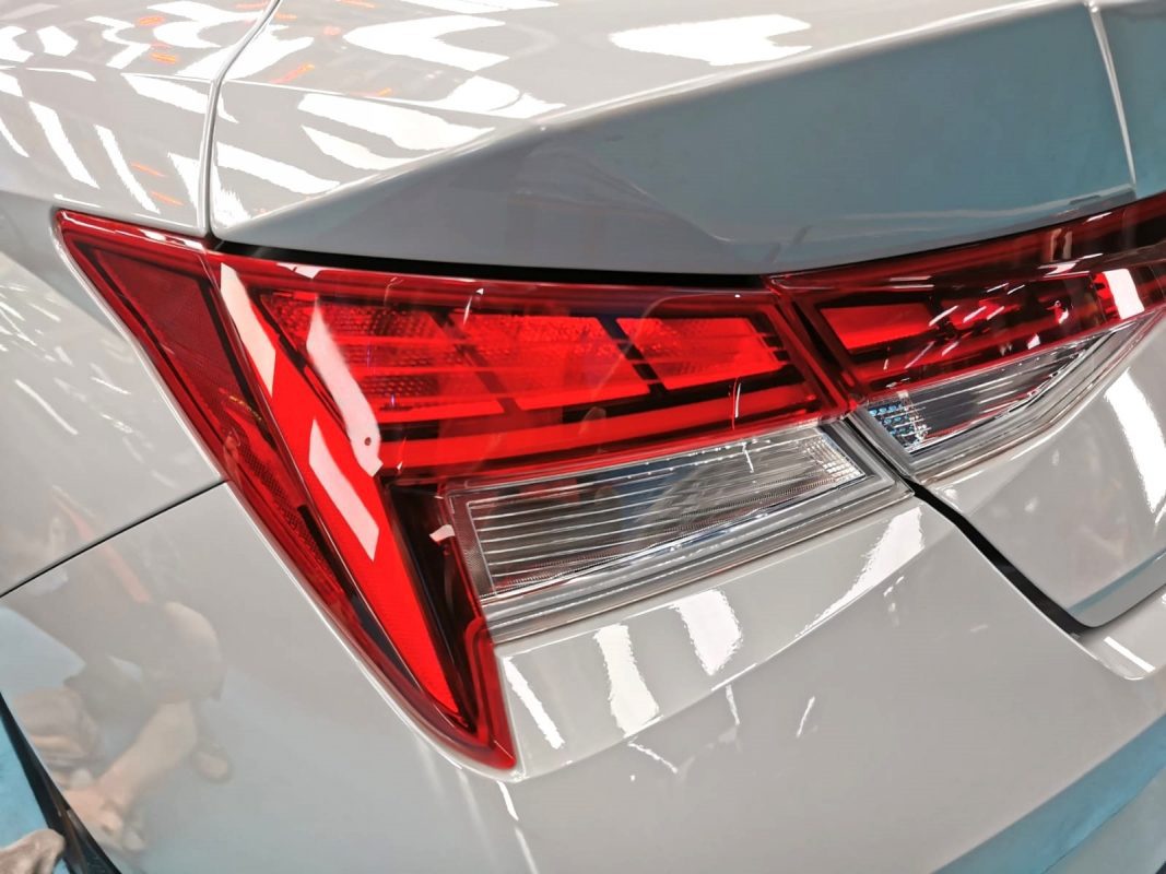 The coated bonnet of the Hyundai CN7 Avante under workshop lighting.