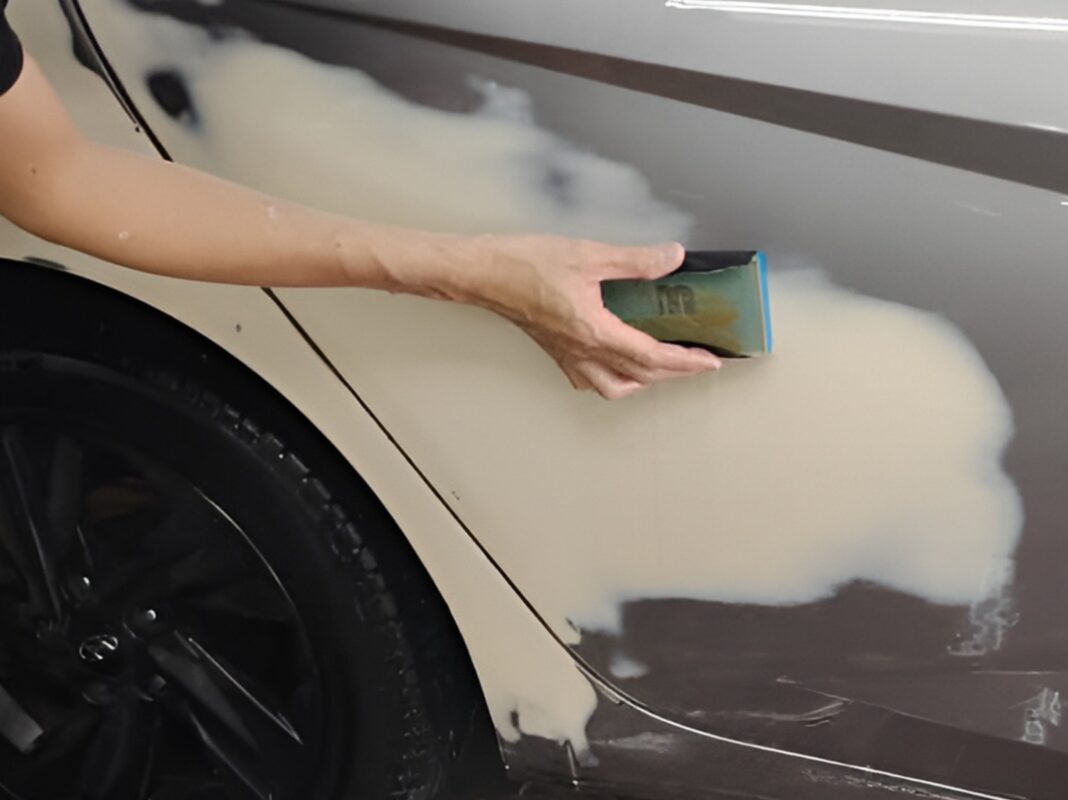 Wet-sanding the body of the Hyundai CN7 to smooth the surface.