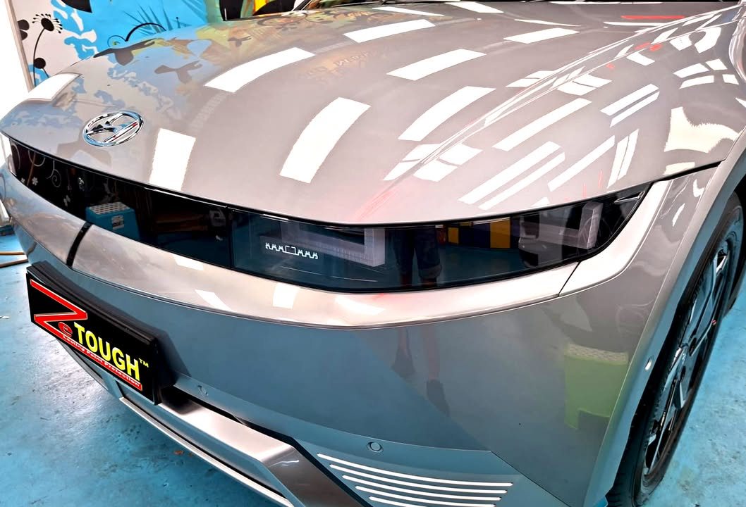 Front of the Ioniq 5 showing the pixel light bar, with light reflections across the bonnet.
