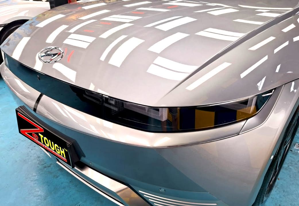 Front of the silver Ioniq 5 with ceiling lights reflected across the bonnet.