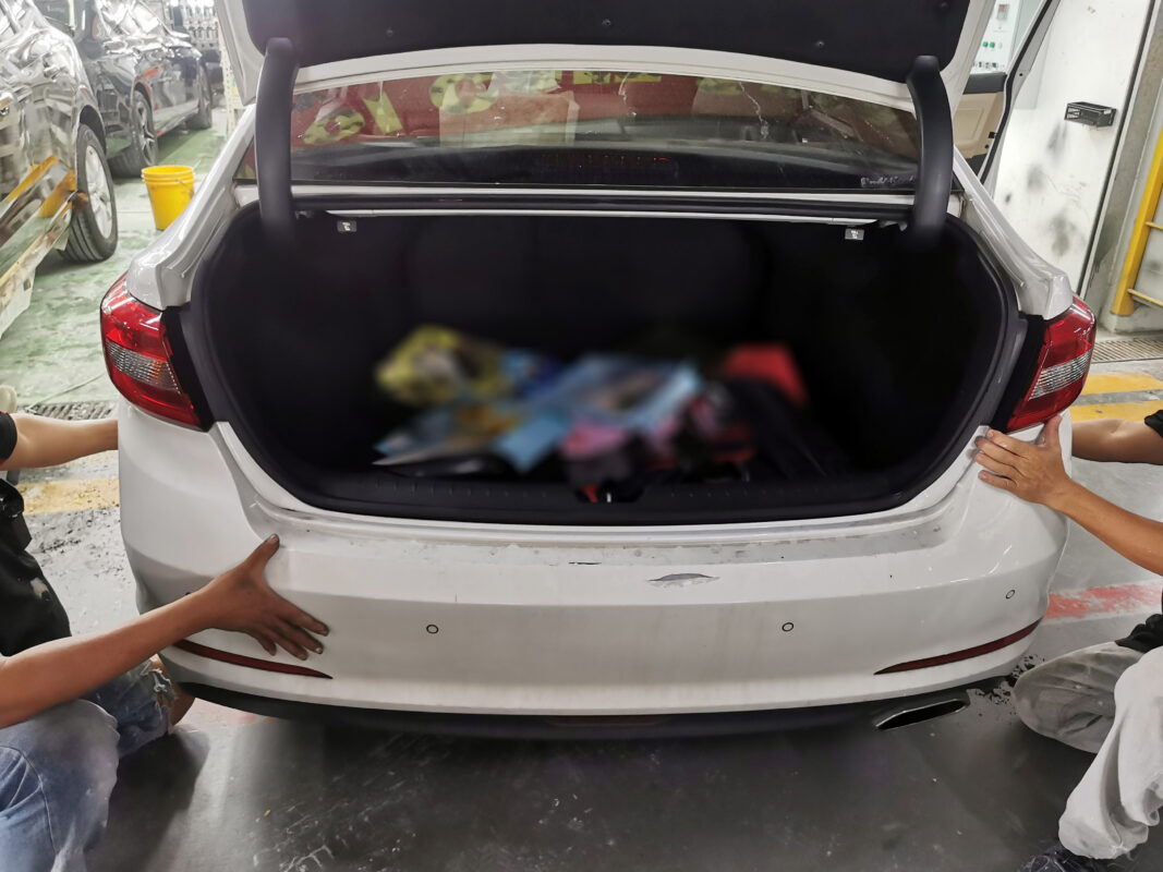 A technician dismantling parts from the Hyundai Sonata at the start of strip-down.