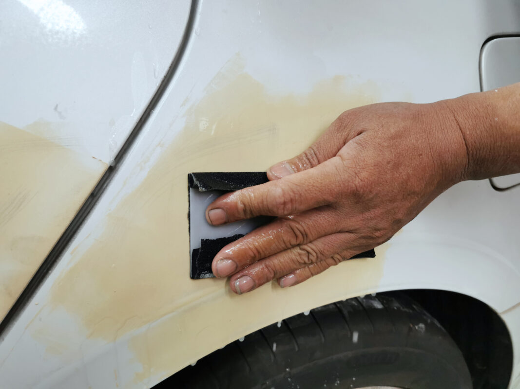 Wet-sanding the Sonata's panels after putty and filler work.