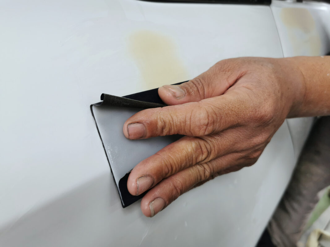 Primer coat applied across the Sonata's panels to seal and level the surface.