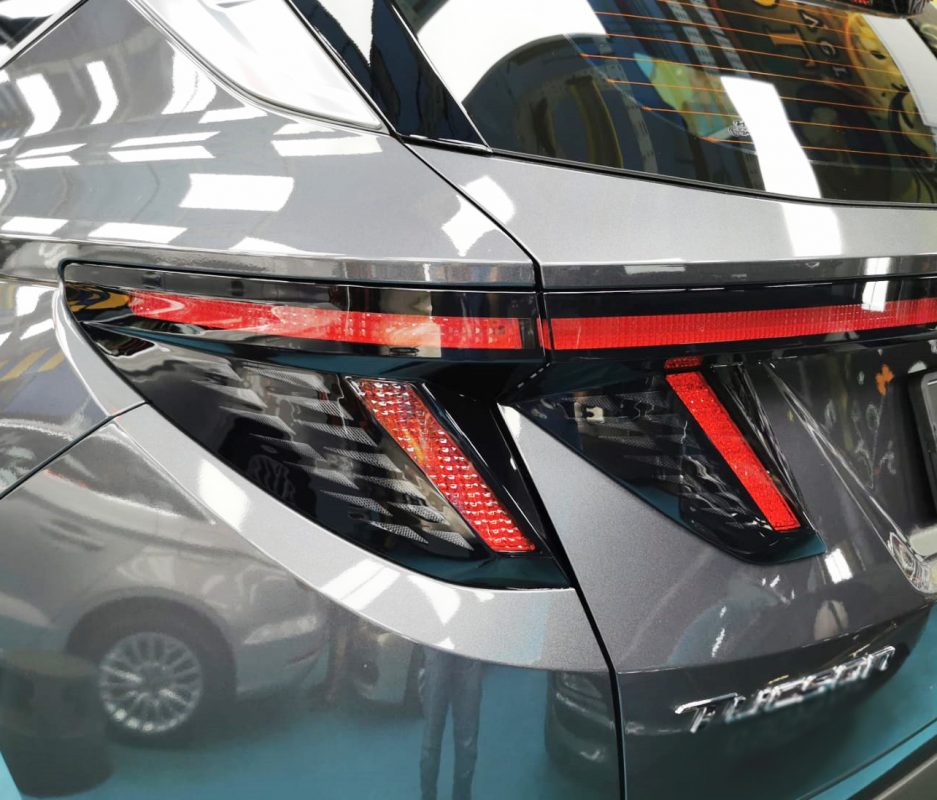 The coated bonnet of the Hyundai NX4 Tucson under workshop lighting.