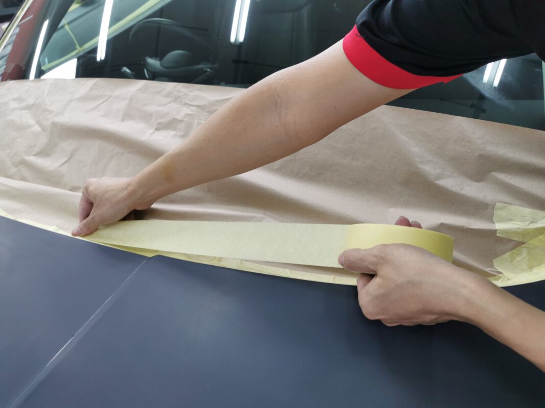 Masking the Hyundai Tucson with paper and tape before the spray booth.