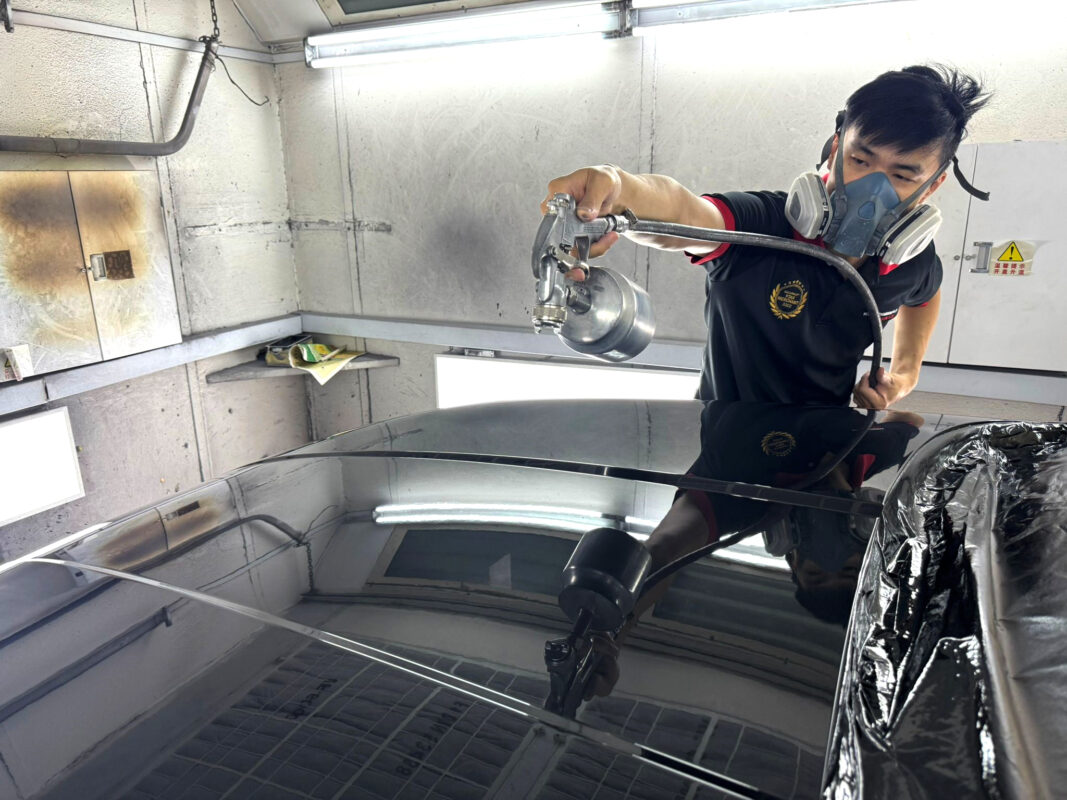 Hyundai Tucson in the spray booth, first coat of fresh paint being applied.