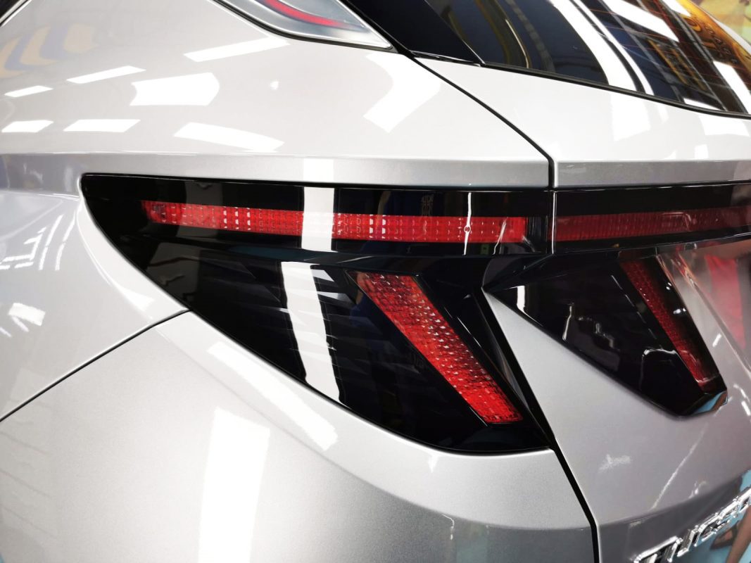 The coated bonnet of the Hyundai NX4E Tucson under workshop lighting.