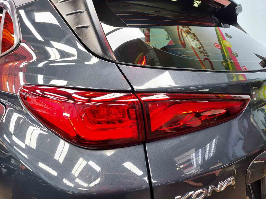 The coated bonnet of the Hyundai OS Kona under workshop lighting.