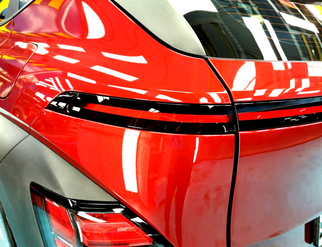 The coated bonnet of the Hyundai SX2 Kona under workshop lighting.