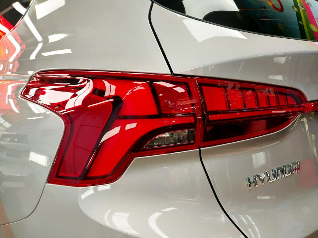 The coated bonnet of the Hyundai TM Santa Fe under workshop lighting.