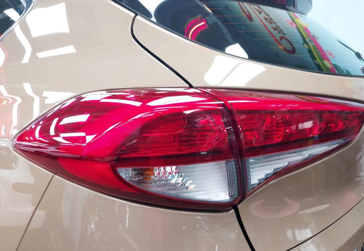 The coated bonnet of the Tucson under workshop lighting.
