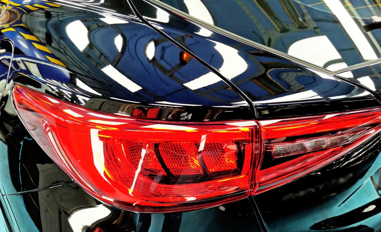 The coated bonnet of the Infiniti Q30 under workshop lighting.