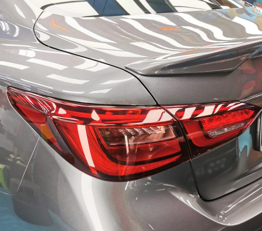 The coated bonnet of the Infiniti Q50 under workshop lighting.